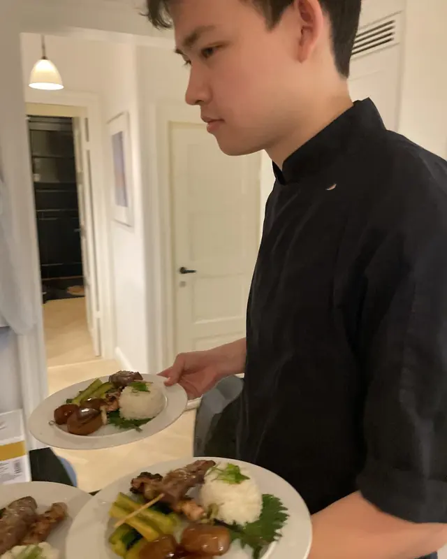 Chef serving plates with skewers and rice